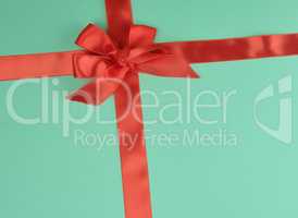 stretched red silk ribbon and tied bow, green background