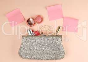 open silver clutch and cosmetics fell out of the middle
