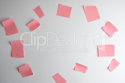 crumpled empty torn pieces of pink paper on a white background