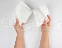 female hands holding a clean white paper napkin for face and bod