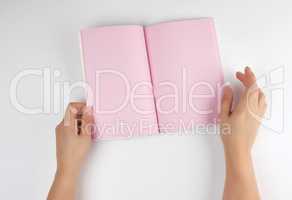 two female hands holding open notepad with clean pink sheets