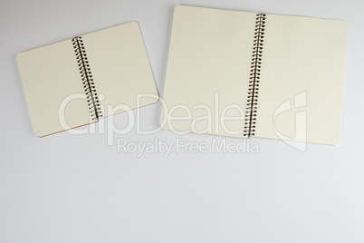 two open spiral notepad with empty white sheets
