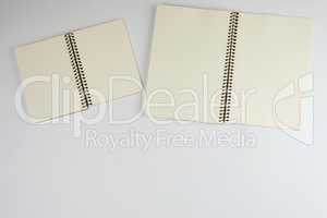 two open spiral notepad with empty white sheets