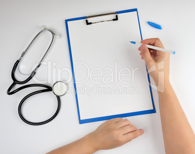 female hand holding a pen for writing a diagnosis or prescriptio