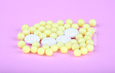 yellow vitamins on pink background