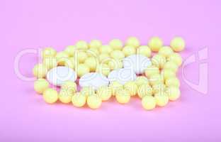 yellow vitamins on pink background