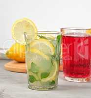 lemonade with lemons, mint leaves, lime in a glass and red berry