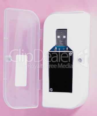 electronic device in plastic case on pink background at day