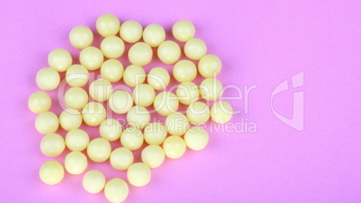 yellow vitamins on pink background