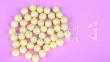 yellow vitamins on pink background