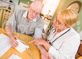 Female Nurse or Doctor Helping Senior Adult Man Take Blood Pressure