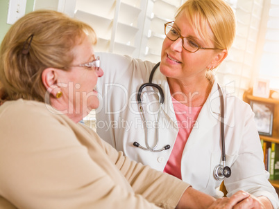 Happy Smiling Doctor or Nurse Talking to Senior Woman in Chair