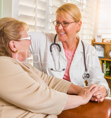 Happy Smiling Doctor or Nurse Talking to Senior Woman in Chair