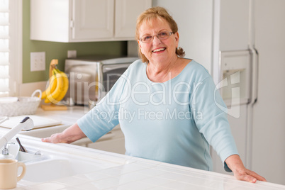 Portrait of A Beautiful Smiling Senior Adult Woman in Kitchen