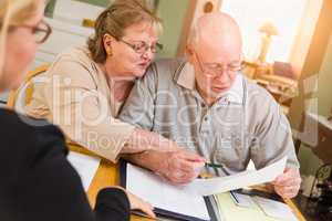 Senior Adult Couple Going Over Documents in Their Home with Agent