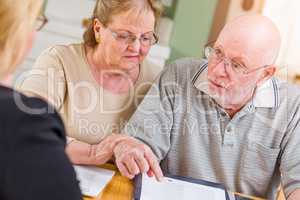 Senior Adult Couple Going Over Documents in Their Home with Agent