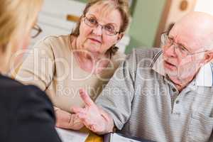 Senior Adult Couple Going Over Documents in Their Home with Agent