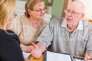 Senior Adult Couple Going Over Documents in Their Home with Agent