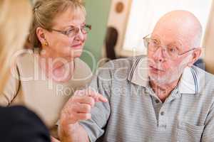 Senior Adult Couple Going Over Documents in Their Home with Agent