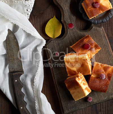 baked square pieces of pumpkin cheesecake on a wooden board