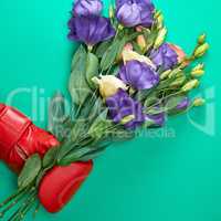 hand in a red boxing glove holding a bouquet of flowers Eustoma