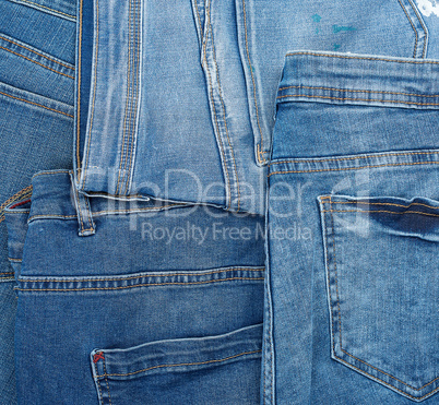 Lots of blue classic jeans stacked chaotically, back pocket