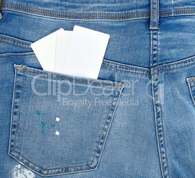 empty white paper card is in the back pocket of blue jeans