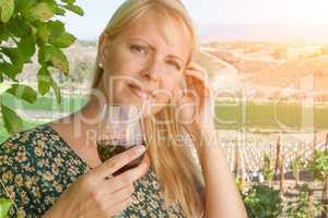 Beautiful Young Adult Woman Enjoying Glass of Wine In The Vineyard