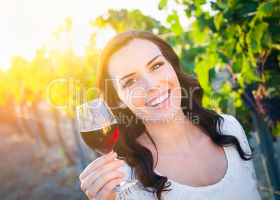 Beautiful Young Adult Woman Enjoying Glass of Wine in the Vineyard