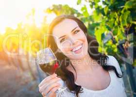 Beautiful Young Adult Woman Enjoying Glass of Wine in the Vineyard