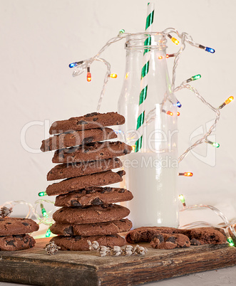 stack of round chocolate chip cookies on a brown wooden board