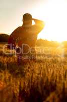 African woman in traditional clothes standing in a field of crop