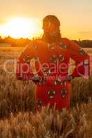 African woman in traditional clothes standing in a field of crop