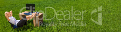 Panorama Businesswoman Relaxing at a Desk In Green Field Banner