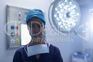Young female surgeon standing in operation theater at hospital.