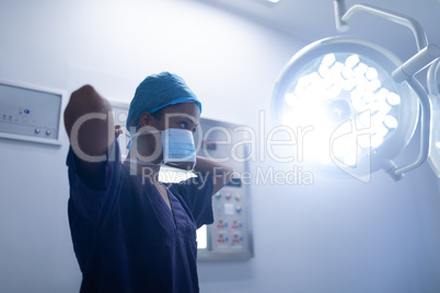Female surgeon wearing surgical mask in operation theater at hospital