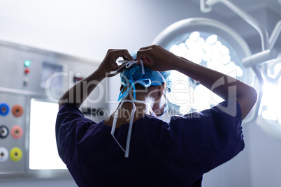 Female surgeon wearing surgical mask in operation theater at hospital