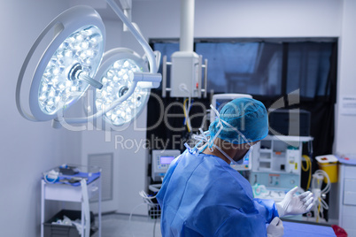 Male surgeon wearing medical gloves in operation theater