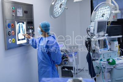 Male surgeon reading x ray in operating room