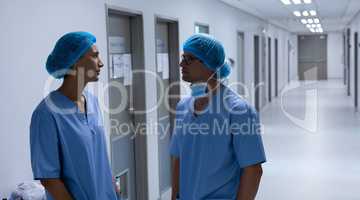 Surgeons talking with each other in the corridor at hospital