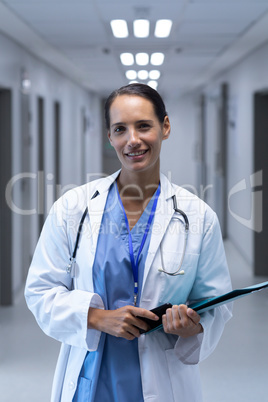 Female doctor looking at camera in the corridor at hospital