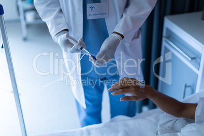Male doctor injecting injection to female patients intravenous drip in the ward at hospital