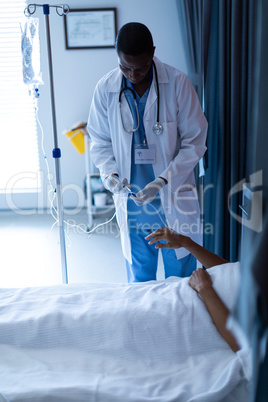 Male doctor injecting injection to female patients intravenous drip in the ward