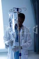 Male doctor checking intravenous therapy drip in the ward