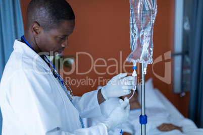 Male doctor injecting injection to female patients intravenous drip in the ward