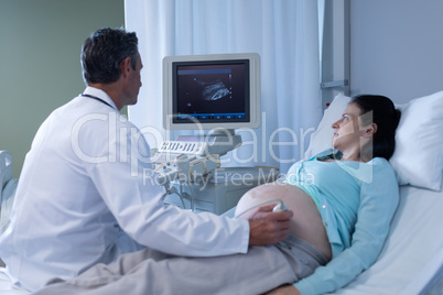 Doctor doing ultrasound scan for pregnant woman in hospital