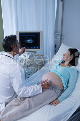 Doctor doing ultrasound scan for pregnant woman in hospital