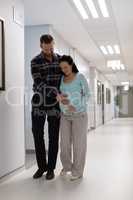 Man comforting pregnant woman while walking in the corridor