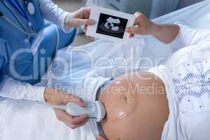 Doctor doing ultrasound scan for pregnant woman in the hospital