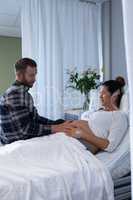 Man comforting pregnant woman in ward